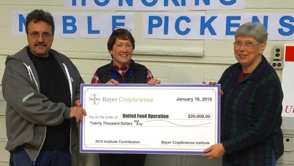 Connie Stewart, center, and Cliff Means present a check for $20,000 dollars from Bayer CropScience to support United Food Operation programs. Receiving the check is UFO Chairperson Elaine Harris.